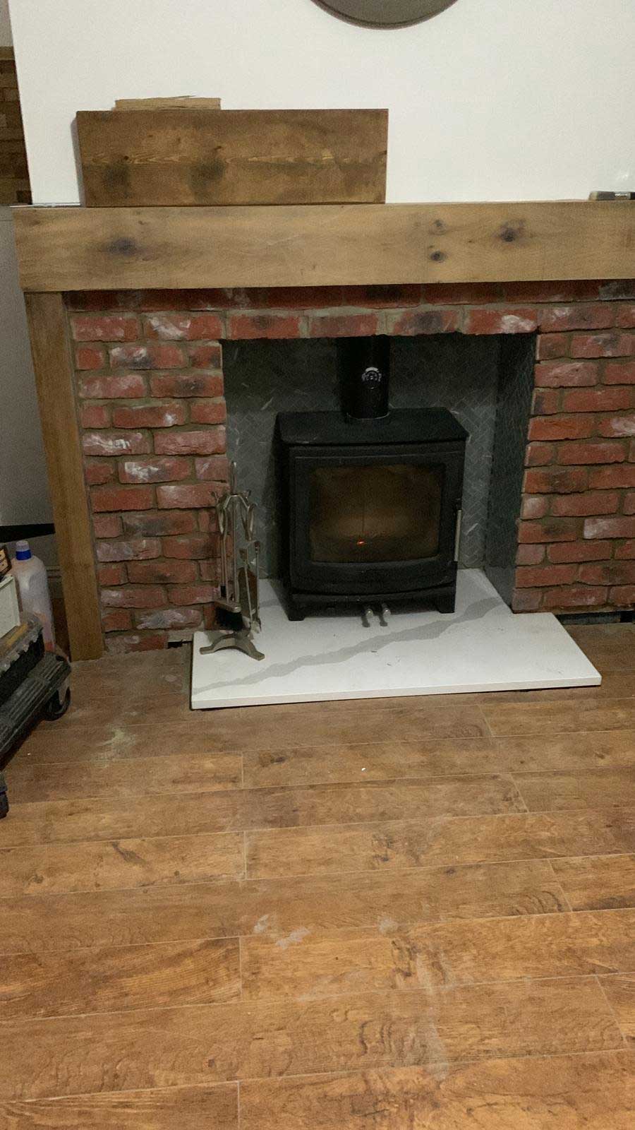 Log burner feature with brick surround and reclaimed beam